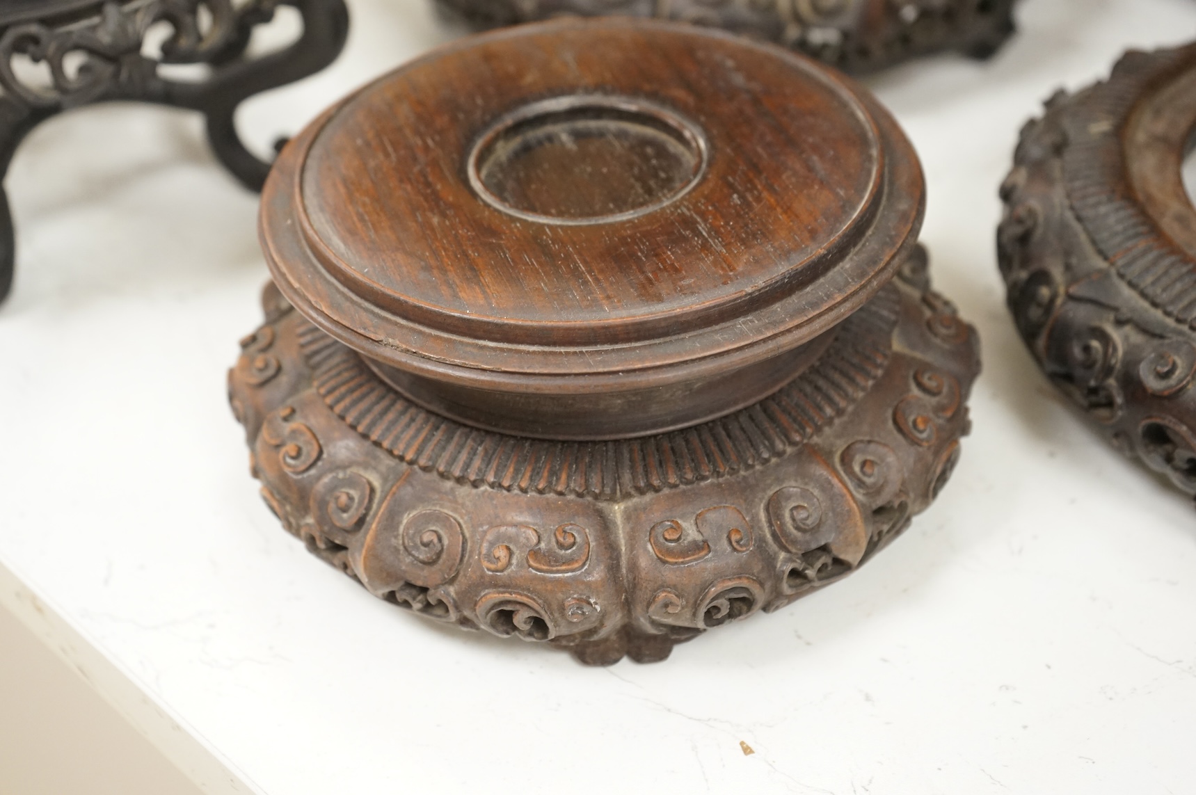 A collection of five Chinese and Japanese carved hardwood stands, late 19th/early 20th century, largest 25cm in diameter
